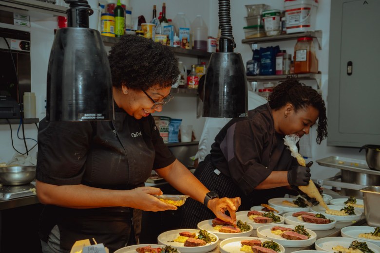 Chefs India Johnson (left) and Dene Lynn (right) putting the final touches on a dish. (Provided by The New South)