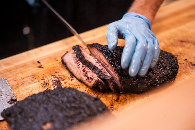 A kitchen member slices Texas-style brisket to order. 
