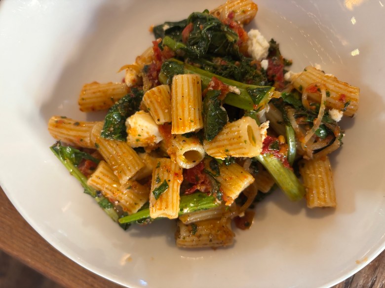 The pesto e pomodoro sees rigatoni tossed in a zesty sun-dried tomato pesto mixed with sauteed rapini leaves and stems, fennel fronds, and crumbles of feta cheese at A Mano in Atlanta.