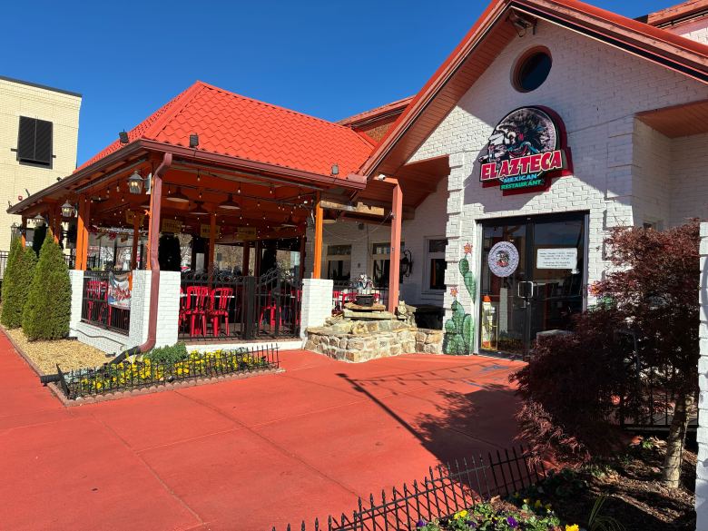 The white exterior with burnt orange roof of El Azteca on Roswell Road in Sandy Springs