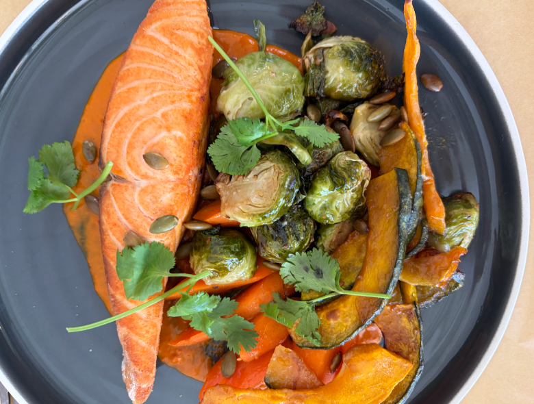 Overhead shot of roasted salmon, Brussels sprouts, carrots, and kabocha squash. 