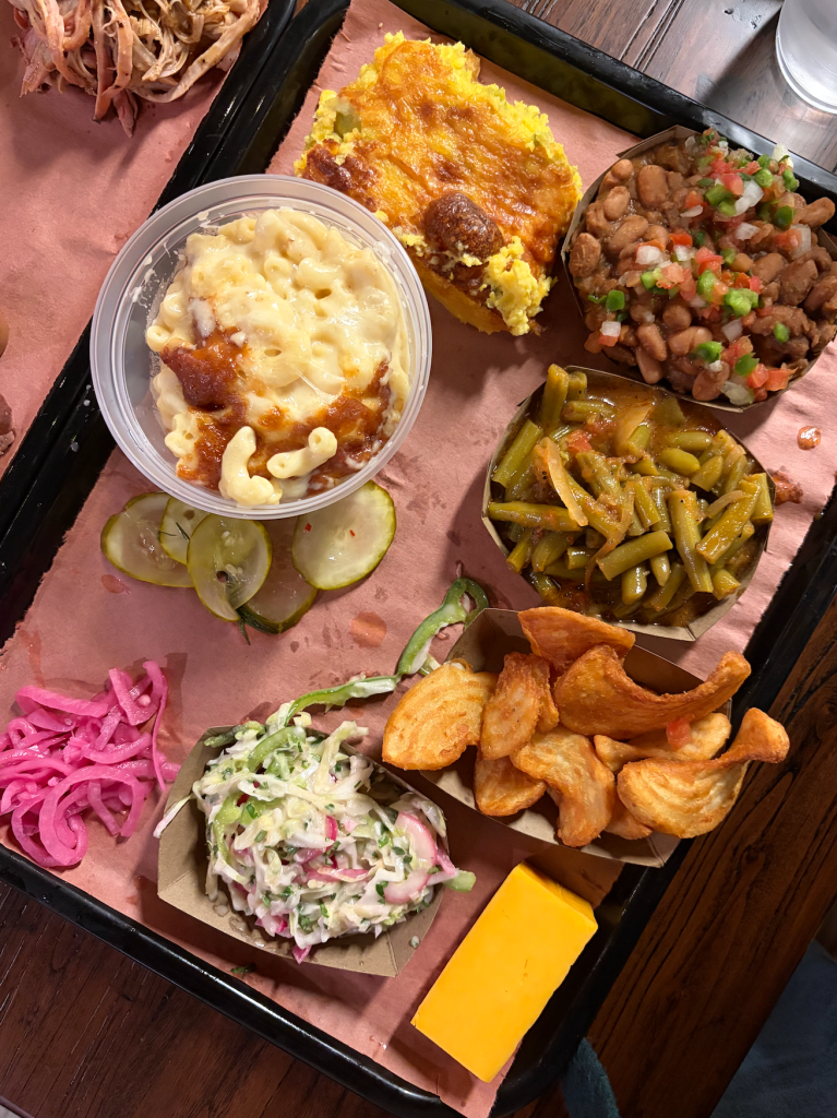 A paper-lined tray topped with barbecue sides. 