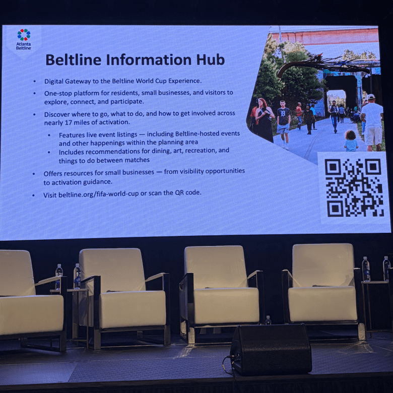 Large projector board showing a slide outlining the Atlanta Beltline's new Beltline Information Hub, a digital resource for residents, visitors, and entrepreneurs ahead of the 2026 World Cup. 